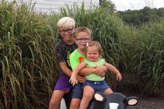 Three-children-on-metal-garden-cow